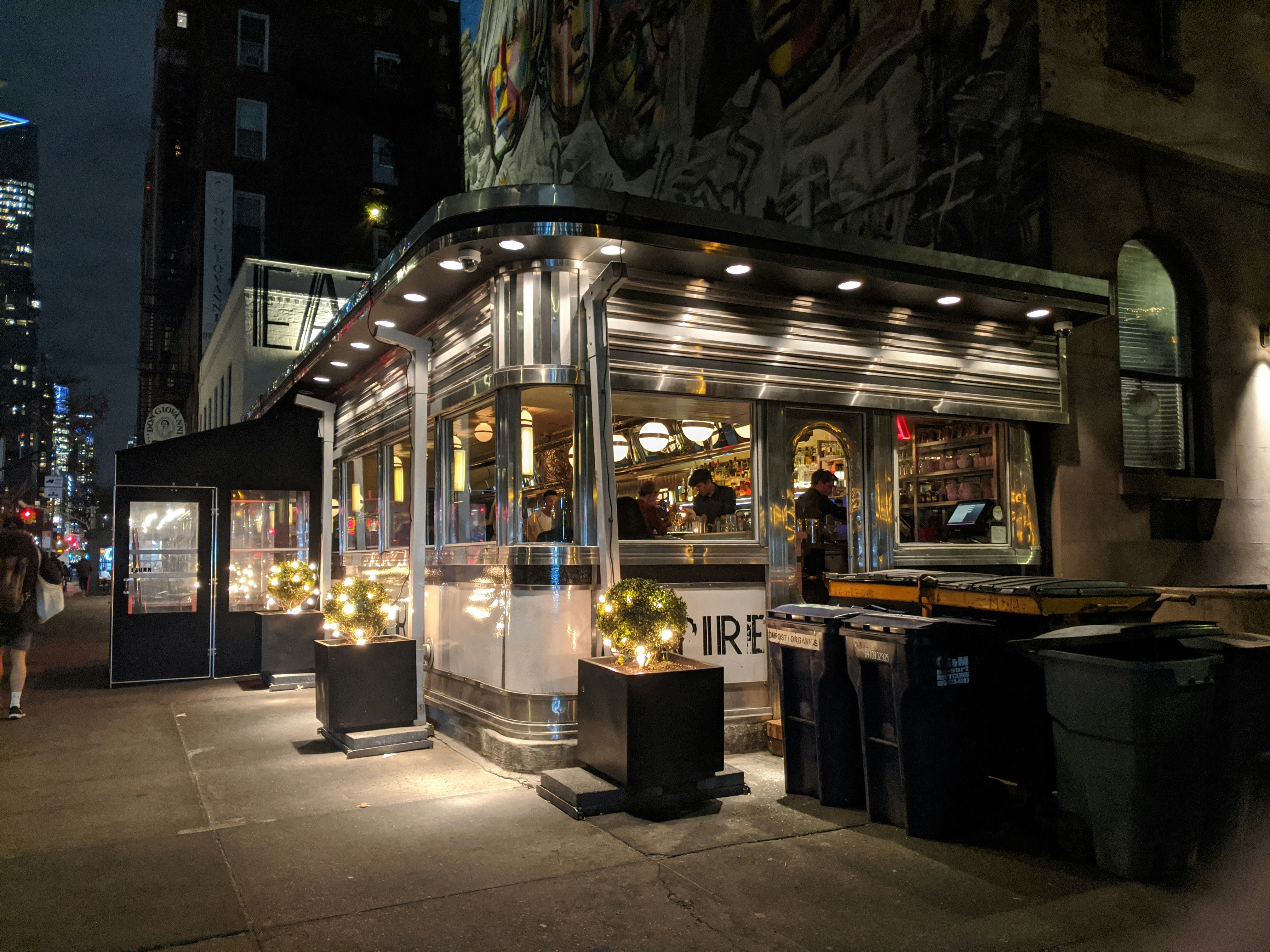 The Empire Diner at night in Chelsea, Manhattan, NYC. Photographed in January, a sidewalk vestibule is seen in front of the entrance to insulate diners from the cold winter air. Photo by Lee Ball.